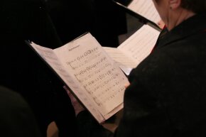 Chorsängerin Blick auf aufgeschlagene Noten